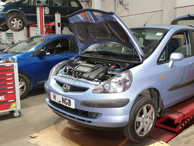 Honda Jazz on workshop ramp has new headlights fitted Honda Jazz on workshop ramp